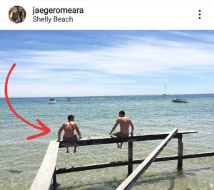 Jaeger O'Meara sitting on post by ocean in poor posture knee tendonitis
